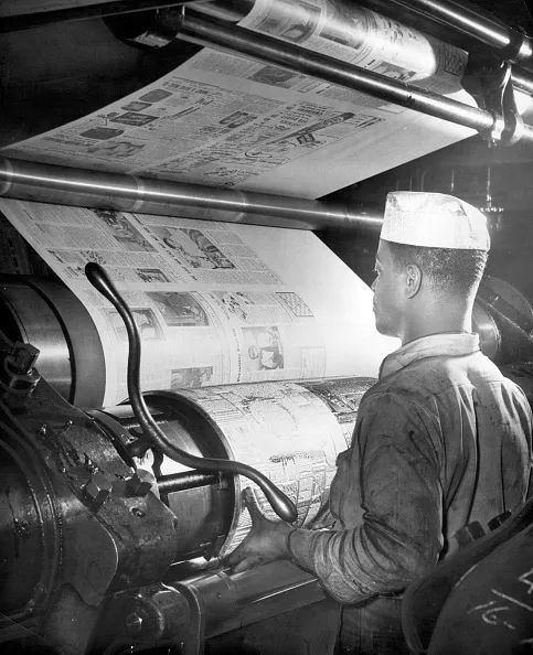 Pressman Joseph Goldman placing a metal plate on AFRO's Goss press in the print room_Image 2 of 4