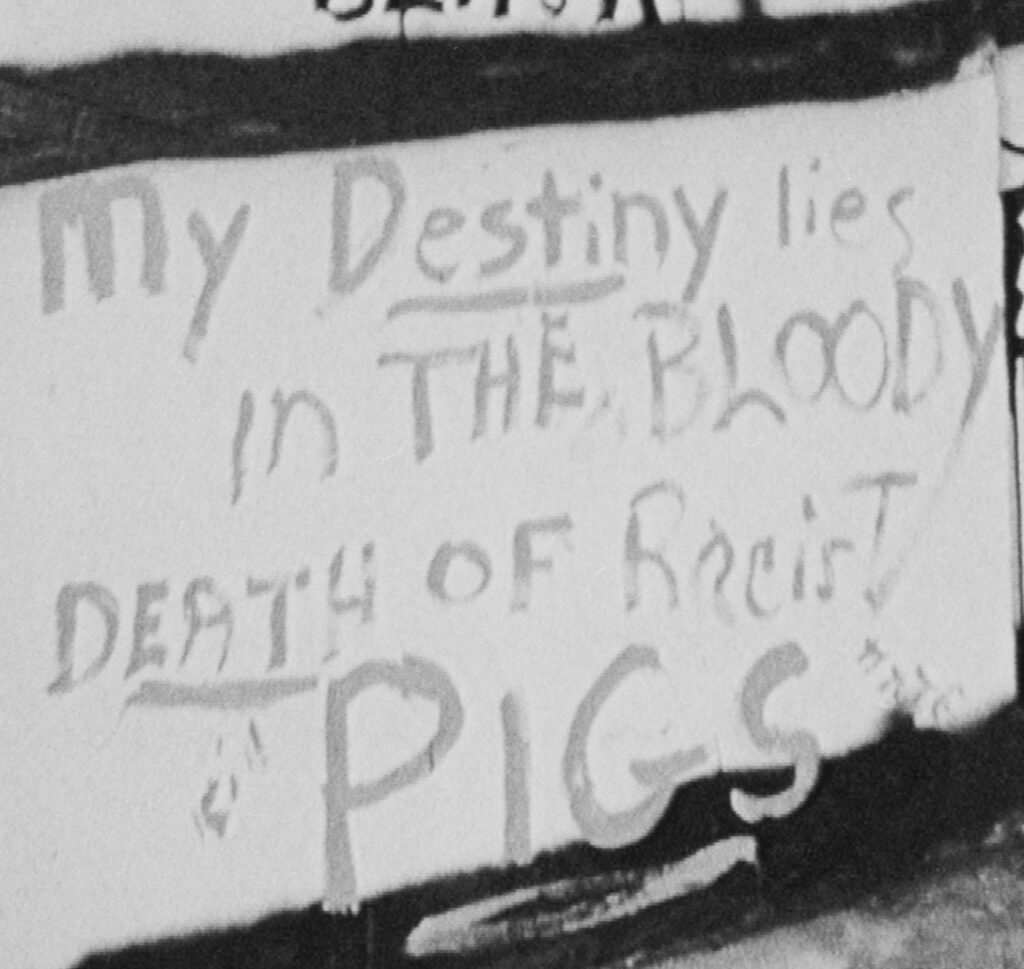 Close up of graffiti that says "my destiny lies in the bloody death of racist pigs"