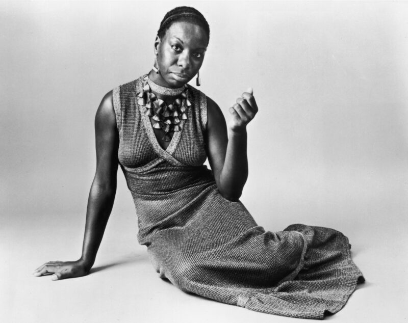 Circa 1968: Studio portrait of American pianist and jazz singer Nina Simone (1933 - 2003) reclining on the floor while wearing a sleeveless, V-neck dress with a shell neckpiece.