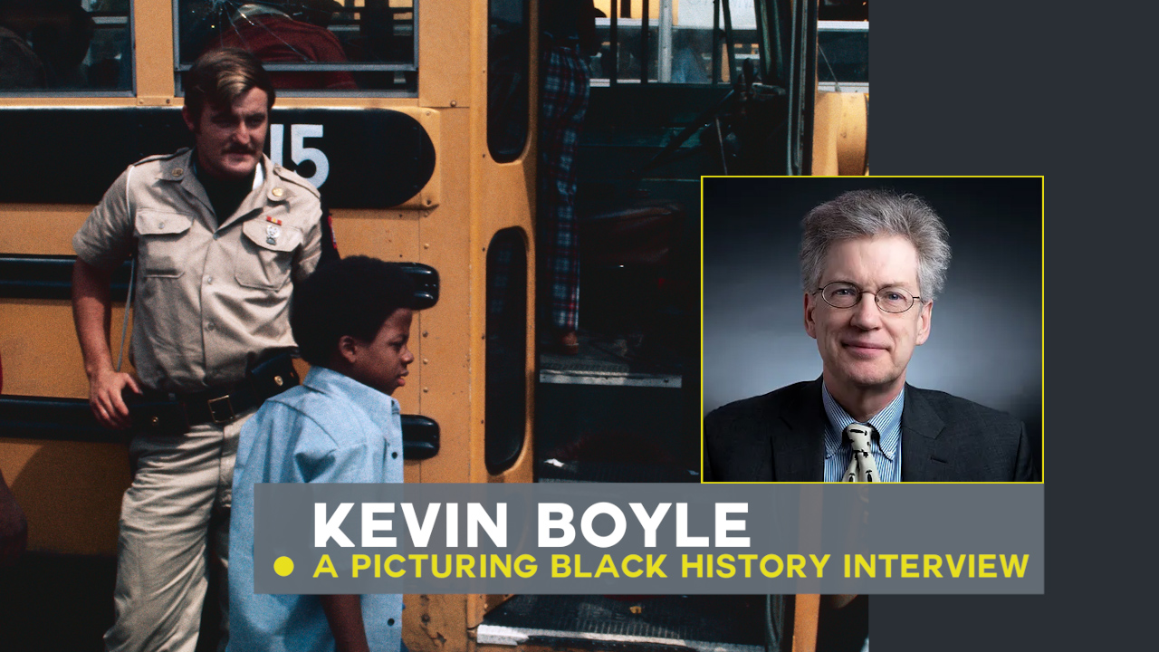 Kevin Boyle with busing image in background