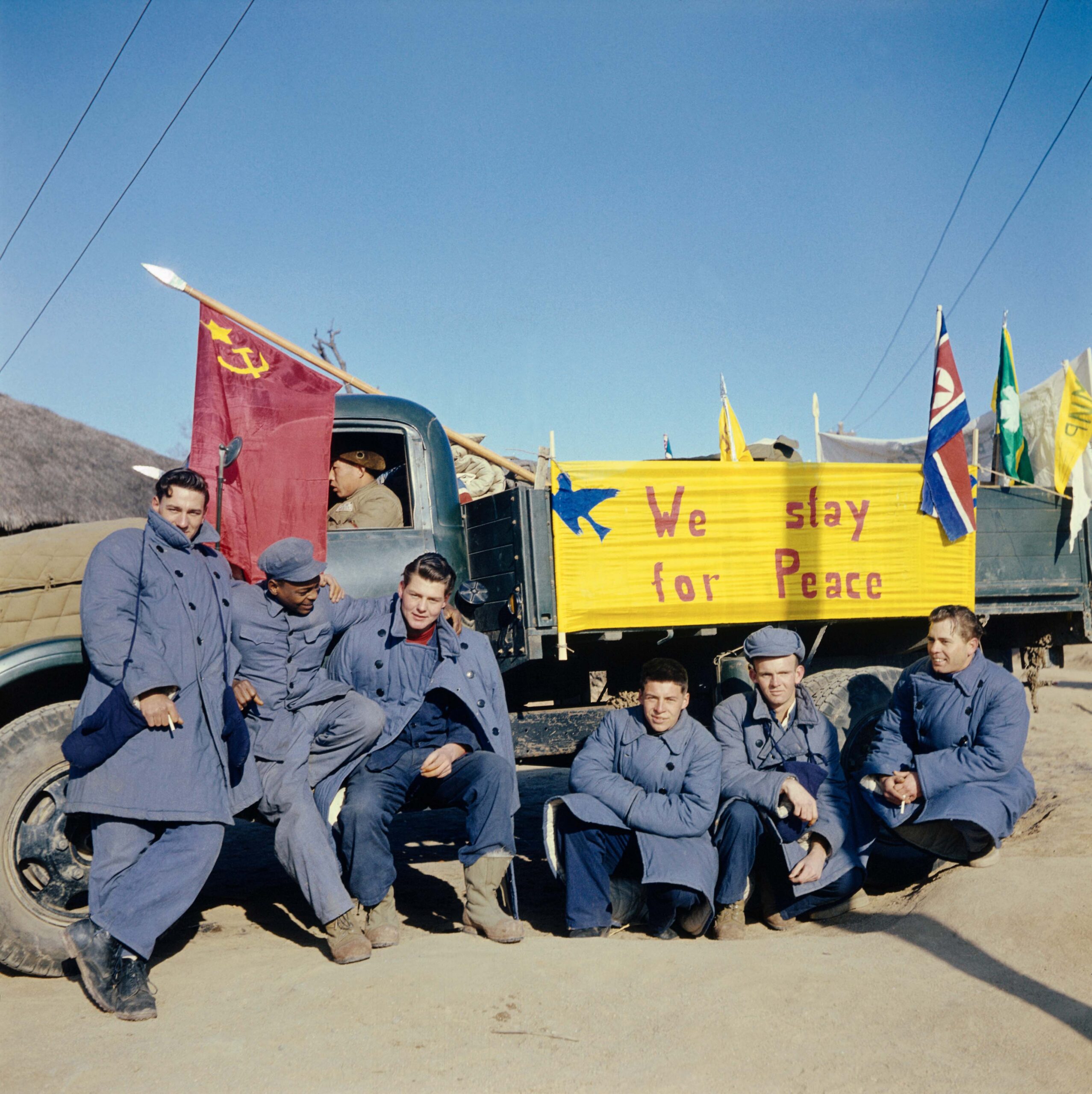 Five of the 21 American soldiers who refused to return to America at the end of the Korean War. The sign on the truck reads: "We Stay for Peace." They moved to China; by the 1960s, all but two had returned home.