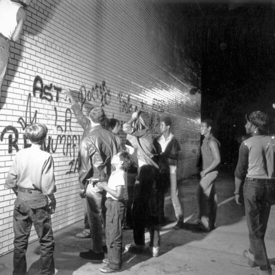 July 1972: A group of youths spraypaint graffiti on a New York wall.