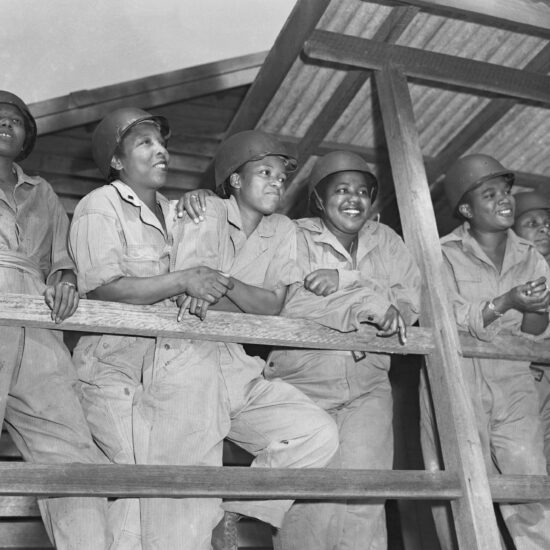 Leaning on a porch rail, waiting for their turn at morning exercises are (l-r): 2nd Lts. Joan L. Hamilton, Marjorie S. Mayers, Prudence L. Burnes, and Inez E. Holmes. All are military nurses training to be sent to advanced posts on the Southwest Pacific.