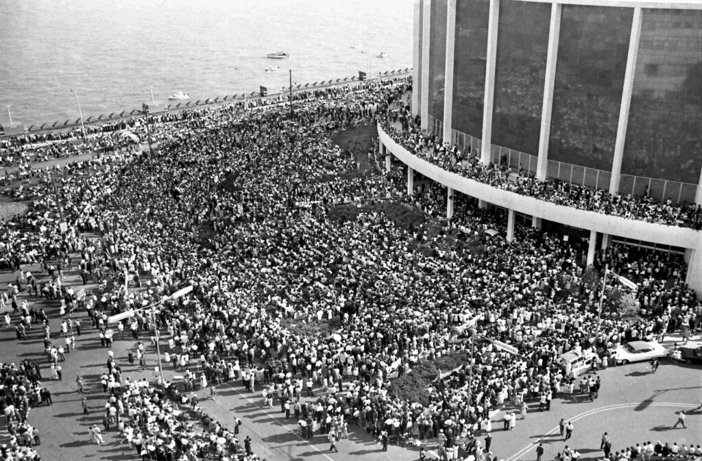 Aerial shot of some of the more than 100,000 people demonstrating in protest of racial discrimination, jam Woodward Avenue, from curb to curb in a huge, but orderly "Walk to Freedom." Most of the marchers entered and surrounded Cobo Hall and Arena to hear Martin Luther King Junior speak.