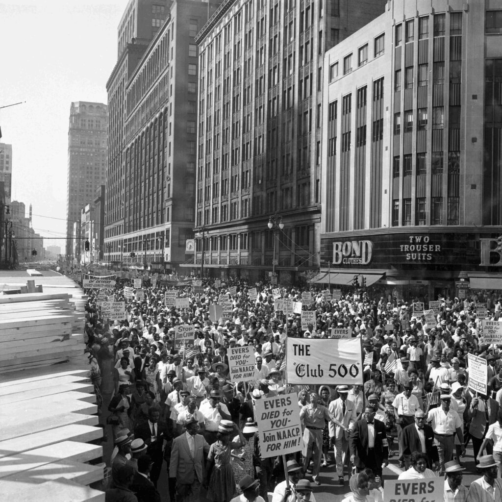 Aerial shot of some of the more than 100,000 people demonstrating in protest of racial discrimination, jam Woodward Avenue, from curb to curb in a huge, but orderly "Walk to Freedom." Most of the marchers entered and surrounded Cobo Hall and Arena to hear Martin Luther King Junior speak.