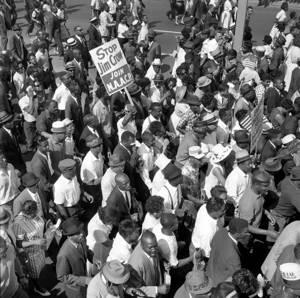 Aerial shot of some of the more than 100,000 people demonstrating in protest of racial discrimination, jam Woodward Avenue, from curb to curb in a huge, but orderly "Walk to Freedom." Most of the marchers entered and surrounded Cobo Hall and Arena to hear Martin Luther King Junior speak.