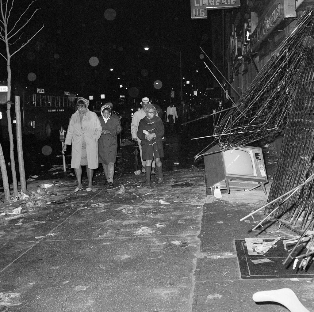 People walk past a television on a sidewalk in Harlem. Many U.S. communities suffered damage during riots in the aftermath of the assassination of Dr. Martin Luther King, Jr.